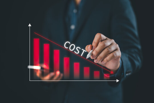 Cost reduction concept, businessman touches pen on virtual screen and decreases arrow of graph, cost text with down arrow, budget, cost management.
