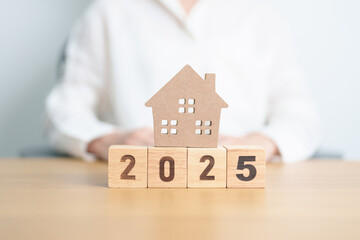Happy New Year 2025 with house model. real estate, Home loan and mortgage, tax, investment,...
