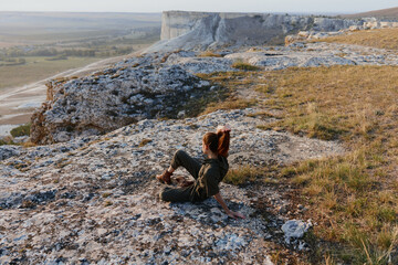 Woman contemplating the majestic beauty of nature a peaceful moment of reflection on the cliff's...