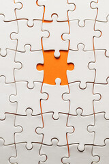 Fototapeta premium Conceptual photo of a puzzle, missing piece, on an orange background