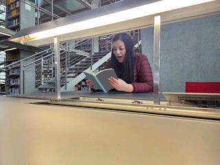 Single 40 year old Latina woman reads books in the library for study and hobby to acquire knowledge...