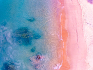 Pink beach with blue ocean waves crashing on sandy shore,Aerial view of holidays beach copy space,Beautiful sand surface Concept holiday summer background Travel destination