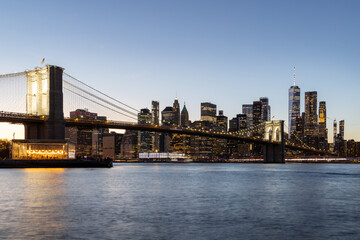 Fototapeta premium A panoramic sunset view of the Brooklyn Bridge stretching towards Manhattan