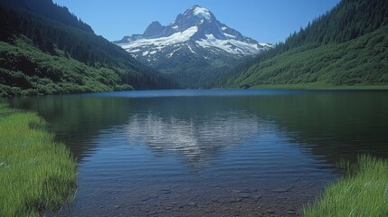 Fototapeta premium A serene mountain landscape reflecting in a calm lake, surrounded by lush greenery.
