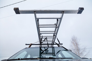 A ladder is attached to the roof of a car
