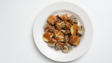 Siomay Bandung (Shumay) or Steamed Siomay. Fish Siomay Served with Peanut Sauce and Chili Sauce on a white background