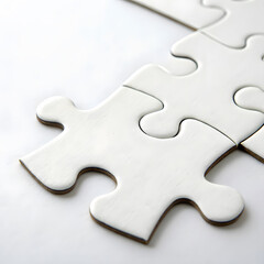 Obraz premium close up of white puzzle pieces on plain background, symbolizing unity and problem solving. simplicity evokes sense of calm and focus