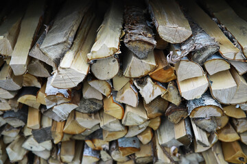Fototapeta premium Stacked Firewood Logs: Neatly Cut Piles for Heating and Outdoor Use