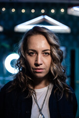 Frontal portrait of a blonde woman with curly hair on a cold background