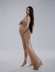 Fototapeta premium beautiful pregnant woman in studio with light drapery like virgin mary