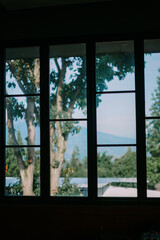 Scenic view through a glass window overlooking trees and a beautiful mountain landscape