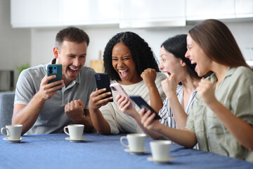 Obraz premium Excited friends celebrating checking their phones