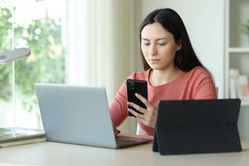 Serious asian woman using multiple devices