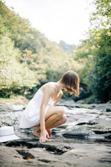 A Graceful Woman is Delightfully Enjoying the Serenity of Nature by the Beautiful Water © pavelvozmischev