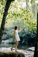 A Serene Woman in a Lovely White Dress Gracefully Embracing Natures Beauty Outdoors