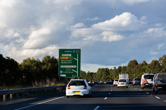 P plater car on road with green roadside signage to Sydney Newcastle and Liverpool