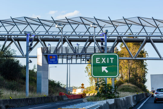 Exit sign and end toll road point signage beside road