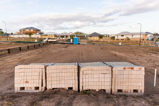 piles of bricks stacked ready for house construction to start on an empty block of land