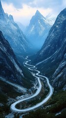 Winding road through a stunning mountain valley in Norway, with dramatic peaks and a blue sky.