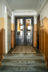 Vintage Interior Hallway with Dark Wooden Double Doors and Stone Steps