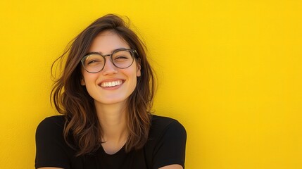 Obraz premium Smiling Young Brunette Woman with Glasses Against Yellow Background