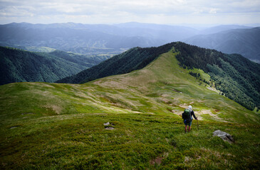 Fototapeta premium Active lifestyle. Traveling, hiking and trekking concept. Young man with backpack in the Carpathian mountains.
