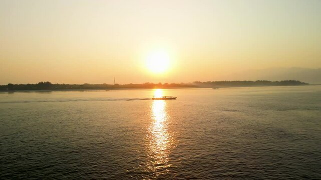 Aerial view of a serene sunset over the sea with a boat on the tranquil waters, Gilli Trawangan, Bali, Indonesia.