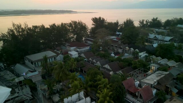 Aerial view of Gilli Trawangan with a boat on the serene ocean at sunset, Bali, Indonesia.