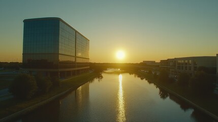 Fototapeta premium Sunset view of modern office buildings reflecting in calm water.