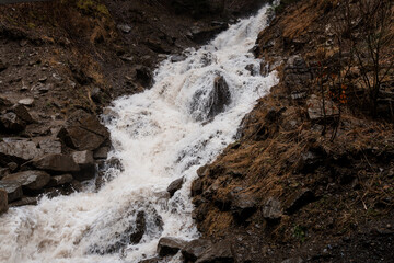 Majestic Waterfall Cascade Flowing Over Rocky Terrain Surrounded by Lush Vegetation