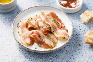 Traditional smoked bacon, sliced on a plate