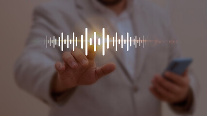 Businessman interacting with a glowing soundwave icon, symbolizing audio technology, voice...