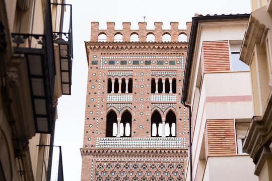 Fototapeta Majestic Mudejar Tower Surrounded by Urban Architecture