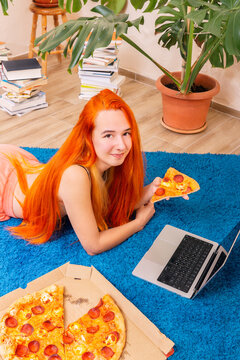 Relaxing at home with pizza and a laptop on a cozy carpet