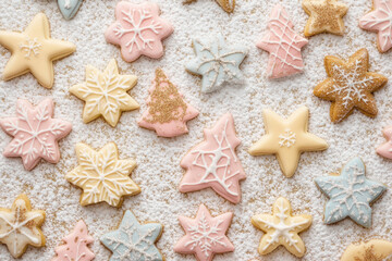 Christmas cookie shapes stars, snowflakes, and trees, rendered in soft pastel tones with subtle gold and silver accents, layered on textured background resembling powdered sugar for copy overlay