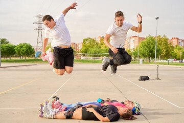 Rollerblading stunt with two men jumping over teammates in a park