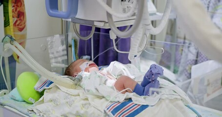 A newborn baby is in a modern incubator or crib in a hospital. Using special equipment, the newborn baby is given an X-ray. Medical staff attending to infant ensuring proper care and monitoring. ICU.
