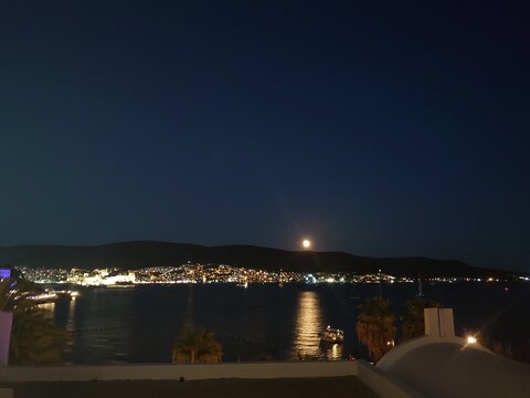 Moon refelecting off hte sea over the city