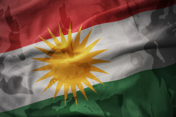 colourful waving flag of kurdistan on the old army khaki texture background. military concept.