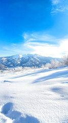 Obraz premium A snowy landscape with majestic mountains under a clear blue sky, showcasing the beauty of winter.