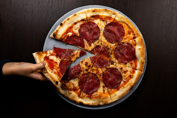 Pizza Salami mit Kinderhand 