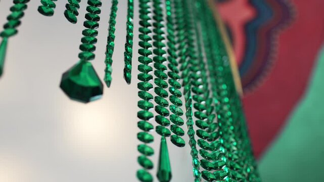 Colorful green beads cascade creating lively atmosphere in well-lit room. Premise adorned with patterned tile evoking warm and inviting feel