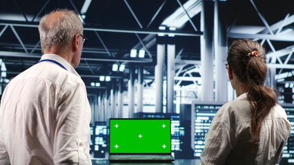 Licensed IT admins looking around high tech data center, using chroma key laptop to crosscheck...