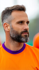 Fototapeta premium focused man in orange sports jersey, showcasing determination and confidence