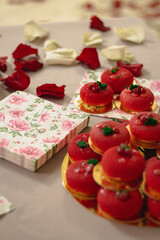 Rows of small, round, red pastries displayed on a plate and tray. Their vibrant color and delicate...