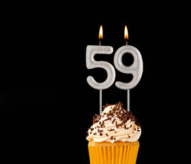 Number 59 shaped candles - Birthday cupcake on black background.