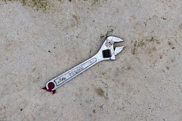 Adjustable wrench on the concrete floor background