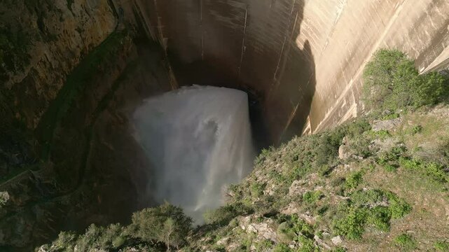 Dam discharge water. Aerial overhead view of water outlet from the dam. Howell Bunger valve in operation in vault dam. Quentar Reservoir. Spain.