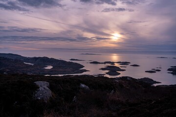 Obraz premium Sunset over rugged coastline and islands