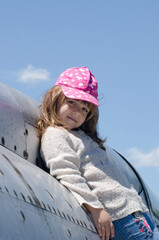 A small girl sitting on an old abandoned plane